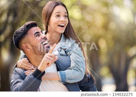Couple, outdoor and pointing at surprise for love, care and happiness together in summer. Young man and woman at nature park for piggyback, laughing or wow at space on happy date or vacation to relax Couple, outdoor and pointing at surprise for love, care and happiness together in summer. Young man and woman at nature park for piggyback, laughing or wow at space on happy date or vacation to relax 134032275