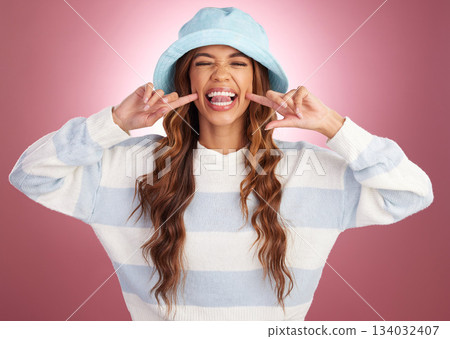Funny, happy and a portrait of a silly woman isolated on a pink background in a studio. Smile, expression and face of a goofy girl being crazy, comical and humorous with fashion on a backdrop 134032407