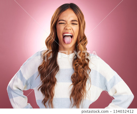 Young woman, funny face and tongue in studio with crazy happiness by gradient background. Student, model and comic time for girl with fashion, comedy or youth with smile, silly and happy by backdrop Young woman, funny face and tongue in studio with crazy happiness by gradient background. Student, model and comic time for girl with fashion, comedy or youth with smile, silly and happy by backdrop 134032412