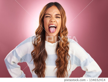 Tongue out, silly and face of woman in studio for crazy, goofy and funny expression isolated on red background. Happiness, comic and smiling with female and fun gesture for confidence, cool and joy 134032414