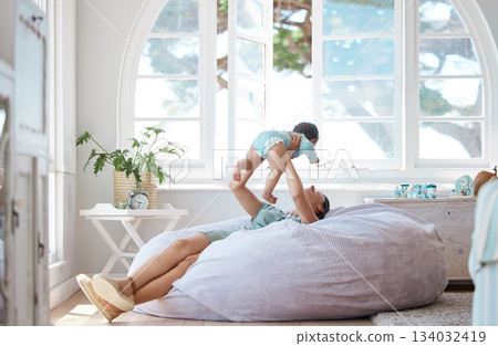Happy mother, play and holding baby in air at home for love, care and quality time together for childhood development. Mom, infant and carrying newborn kid on bean bag, nursery room and relax for fun 134032419