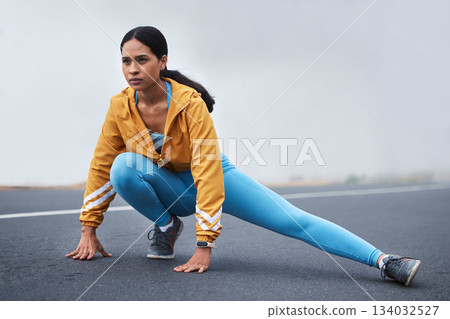 Fitness leg stretching, woman and runner exercise on a outdoor road in the mountains with focus. Workout, running training and wellness of a young female ready for sports and marathon run in mist Fitness leg stretching, woman and runner exercise on a outdoor road in the mountains with focus. Workout, running training and wellness of a young female ready for sports and marathon run in mist 134032527