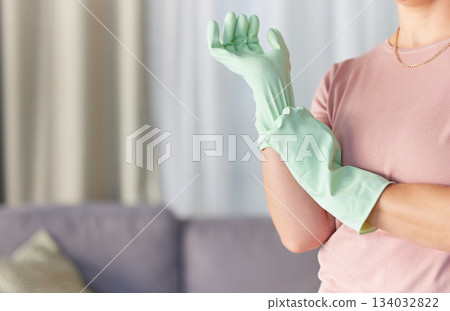 Woman, hands and gloves in housekeeping preparation for cleaning, dirt removal or disinfection in living room at home. Hand of cleaner ready to start spring clean service for safety with rubber glove Woman, hands and gloves in housekeeping preparation for cleaning, dirt removal or disinfection in living room at home. Hand of cleaner ready to start spring clean service for safety with rubber glove 134032822