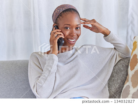Black woman, portrait and phone call on home sofa with a smile for communication and connection. Female model with a smartphone for conversation with network and contact on living room couch to relax 134032827