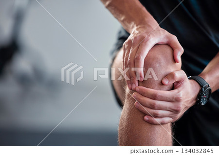 Hands, knee and pain with a sports man holding a joint injury while training in a gym for health. Fitness, accident and anatomy with a male athlete suffering from an injured body during exercise Hands, knee and pain with a sports man holding a joint injury while training in a gym for health. Fitness, accident and anatomy with a male athlete suffering from an injured body during exercise 134032845