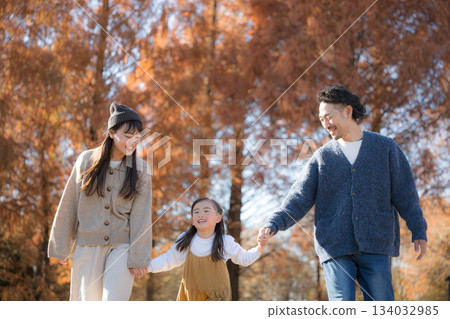 Family playing in the autumn park. Holding hands, image of outing and leisure Family playing in the autumn park. Holding hands, image of outing and leisure 134032985