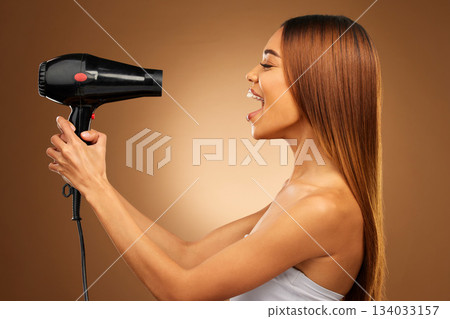 Beauty, styling and hairdryer with woman in studio for hair care, shampoo and grooming. Salon treatment, glow and self care with model isolated on brown background for results, keratin and cosmetics 134033157