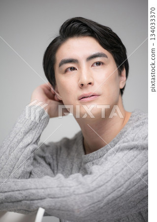Close-up of a thinking man looking up with a gray bag, vertical 134033370