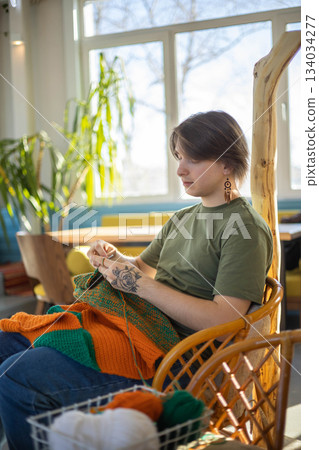 Hipster feminine male crochet handmade knitting hobby with colored yarn and hook at wooden interior Hipster feminine male crochet handmade knitting hobby with colored yarn and hook at wooden interior 134034277
