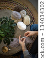 Male hands crochet handmade artwork use wool yarn and hook over table with coffee top view 134034302