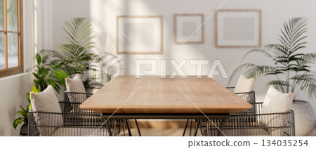 Empty wooden table with armchairs in t living room or a cafe with blank frame hanging on white wall Empty wooden table with armchairs in t living room or a cafe with blank frame hanging on white wall 134035254