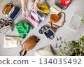A young woman chooses fashionable, trendy, bright, multi-colored bags for herself in home wardrobe 134035492