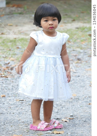Little Asian girl in a white dress in the park 134036845