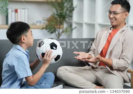 Father and son enjoying soccer, sharing excitement at home Father and son enjoying soccer, sharing excitement at home 134037090