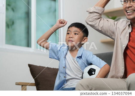 Father and son celebrating soccer success, sharing joyful moments 134037094