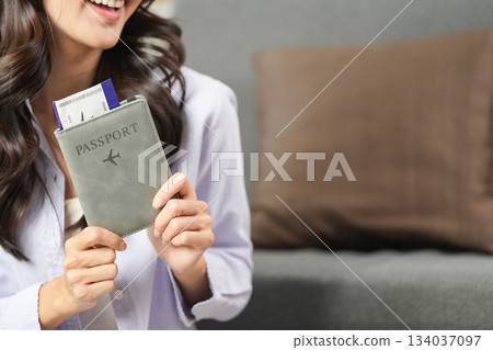 Travel Planning. Woman holding passport and boarding pass, preparing for an exciting journey. 134037097
