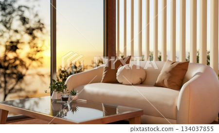 Glass top wooden table and white leather sofa next to glass wall window and sheer curtain in evening 134037855