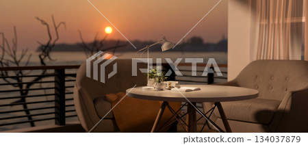 A wooden stool table and armchairs with blanket set on balcony with river or lake view in the sunset 134037879