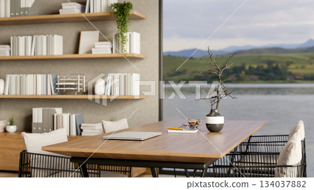 Closed laptop and coffee cup on wooden table in living room with river or lake view outside the door Closed laptop and coffee cup on wooden table in living room with river or lake view outside the door 134037882