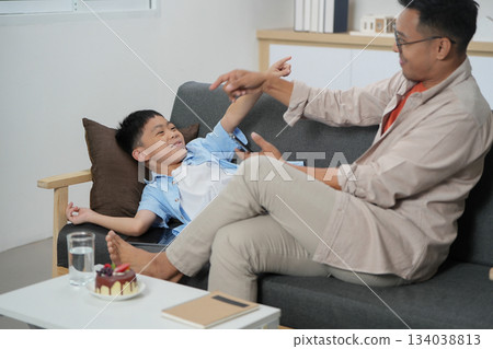 Father and son sharing playful moments, enjoying quality time at home Father and son sharing playful moments, enjoying quality time at home 134038813