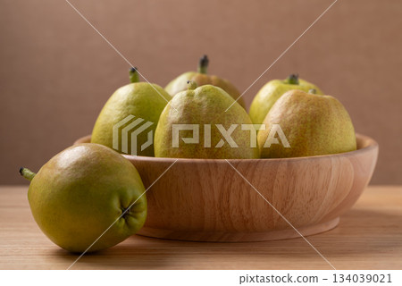 Fresh pear in a bowl on wooden background Fresh pear in a bowl on wooden background 134039021