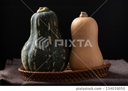 Butternut squash in basket on fabric with black background 134039050