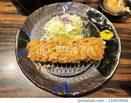 Japanese tonkatsu, a deep-fried pork cutlet, commonly served with shredded cabbage and mustard. Japanese tonkatsu, a deep-fried pork cutlet, commonly served with shredded cabbage and mustard. 134039408