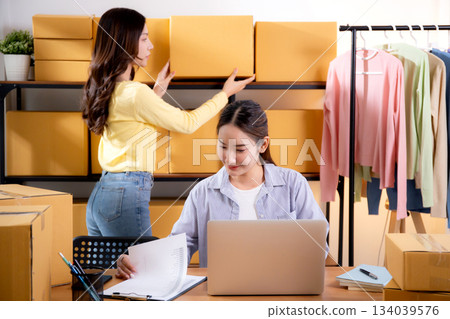 Two young asian businesswoman checking order of customer for laptop computer and document. 134039576