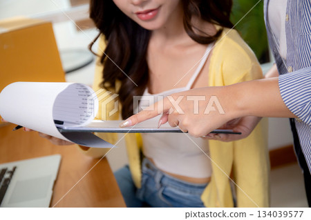 Close up two asian woman working and check document while managing and planning online business. 134039577