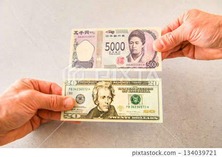 Image angle shot of exchanging one $20 bill for one $5,000 bill 134039721