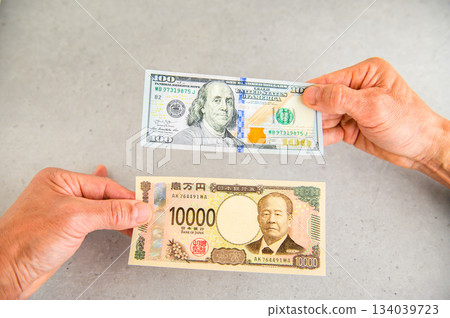 第二張拍攝角度的照片，展示了用一張100美元鈔票兌換一張10000日元鈔票的過程。 134039723