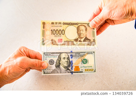 第五張拍攝角度的照片，展示了用一張100美元鈔票兌換一張10000日元鈔票的過程。 134039726
