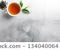 A cup of tea and leaves on a gray stone table 134040064
