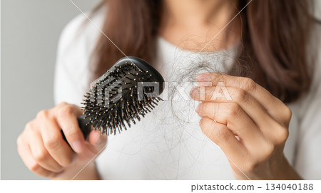 Woman holding comb show her hairbrush with loss hair problem. 134040188