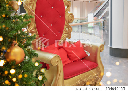 Golden throne with red cushions at christmas tree in mall, waiting for santa 134040435