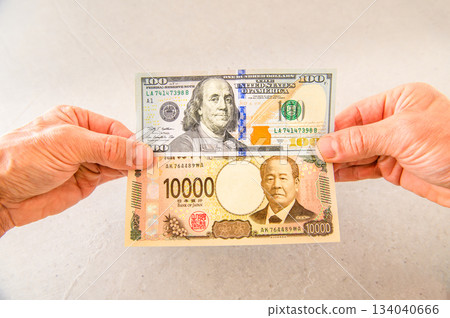 Angle shot 1 holding one $100 bill and one $10,000 bill Angle shot 1 holding one $100 bill and one $10,000 bill 134040666