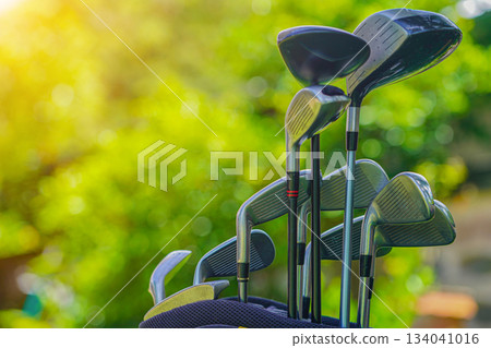 Golf bag and clubs in front of a blurred golf course background. 134041016