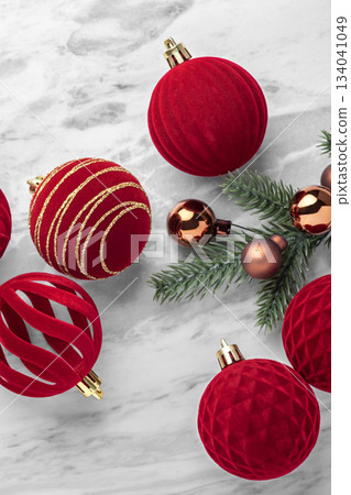 Red velvet baubles, Christmas balls and pine branch ornaments on marble table Red velvet baubles, Christmas balls and pine branch ornaments on marble table 134041049
