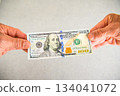 Angle shot of a person holding a $100 bill 134041072