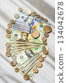 Flat lay of 100, 20, and 1 dollar bills and US coins, light and shadow lighting, vertical composition 2 134042678