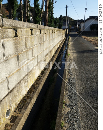 Country road, fence and gutter vertical 134042719