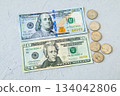 Flat lay of $100 bills, $20 bills and US 25 cent coins 134042806