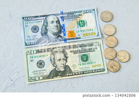 Flat lay of $100 bills, $20 bills and US 25 cent coins 134042806