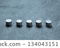 A photo of stacks of Japanese one-yen coins lined up in a horizontal row 134043151