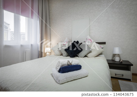 Bright Cozy Bedroom with Towels on Soft Bed Bright Cozy Bedroom with Towels on Soft Bed 134043675