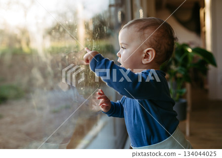 A little toddler is looking out the window. A little toddler is looking out the window. 134044025