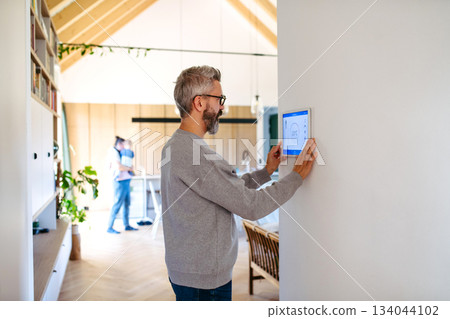 Man using smart home control panel. 134044102