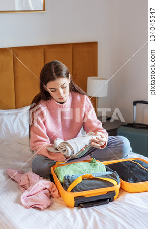 Woman preparing clothes for travel vacation packing suitcase Woman preparing clothes for travel vacation packing suitcase 134045547