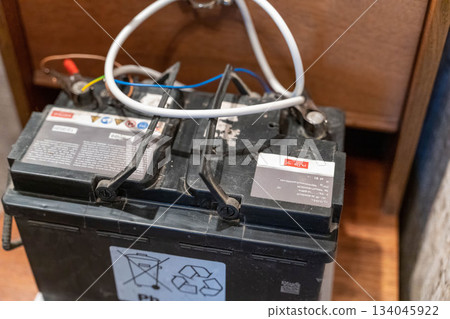 Old lead acid battery stored in a wooden cabinet at a workshop location Old lead acid battery stored in a wooden cabinet at a workshop location 134045922