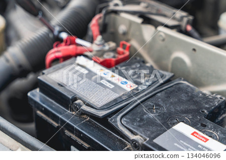 Car battery repair work taking place in an auto shop during the day Car battery repair work taking place in an auto shop during the day 134046096